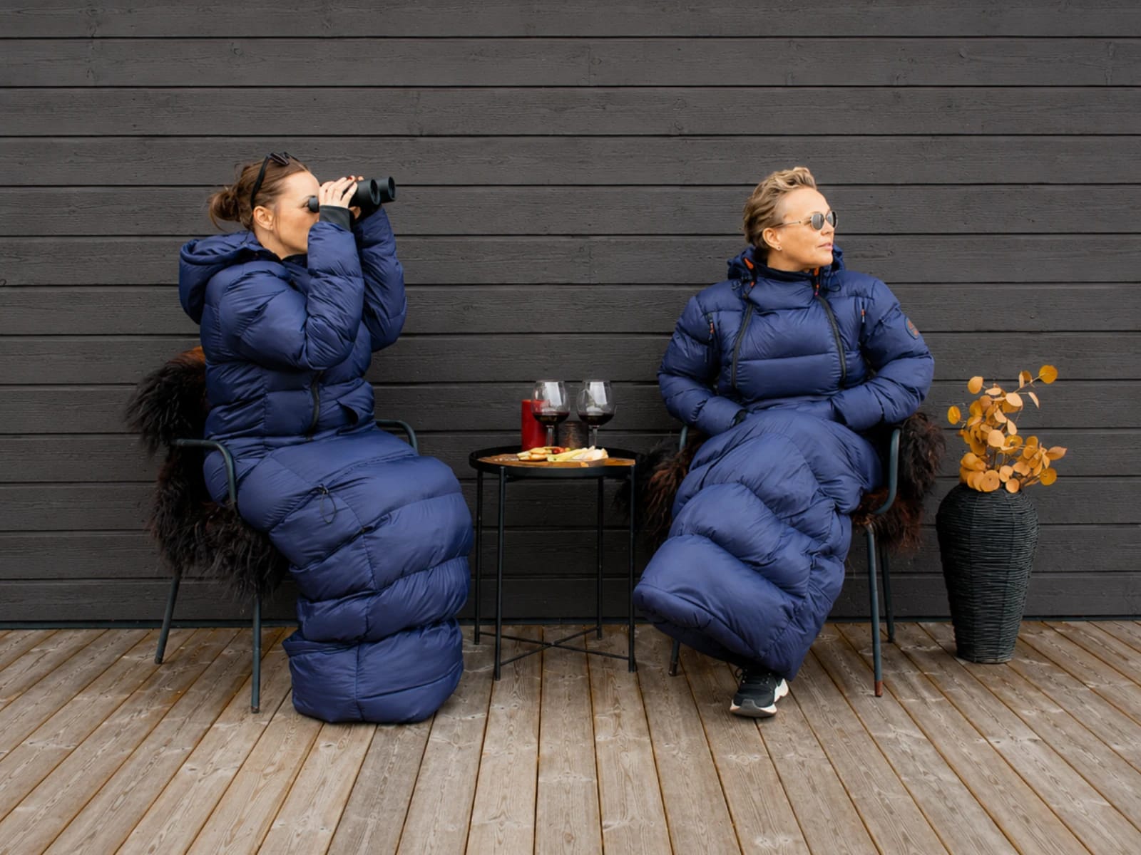 To kvinner i Utekos TechDown sitter på en terassen og nyter ost og vin.